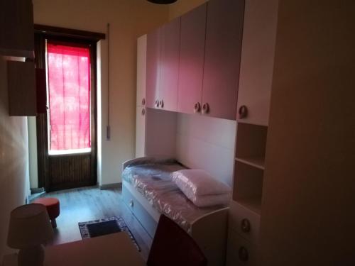 a room with a bed with pink cabinets and a window at Appartamento Roma, in Rome