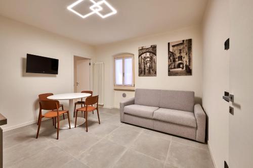 uma sala de estar com um sofá e uma mesa em ApartmentsGarda - Residenza Mercanti em Garda