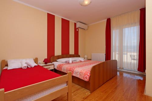 two beds in a room with red and white stripes at Apartments and rooms with parking space Vrbnik, Krk - 5299 in Vrbnik