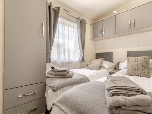 sypialnia z 2 łóżkami i oknem w obiekcie The Cotswold Holiday Lodge w mieście Evesham