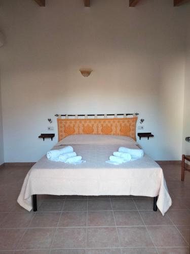 a bedroom with a bed with towels on it at Agriturismo i doni del mandorlo in Alghero