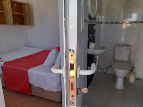 a small bedroom with a bed and a toilet at ERAY PANSİYON in Gokceada Town
