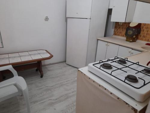 a kitchen with a stove and a white refrigerator at ERAY PANSİYON in Gokceada Town