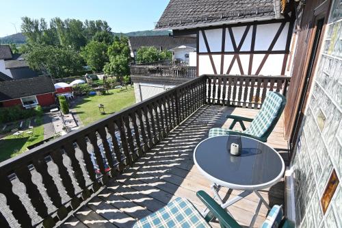 een patio met een tafel en stoelen op een balkon bij Gästehaus Achenbach in Biedenkopf