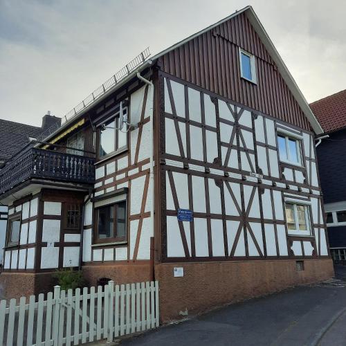 a house with a white fence in front of it at Gästehaus Achenbach in Biedenkopf