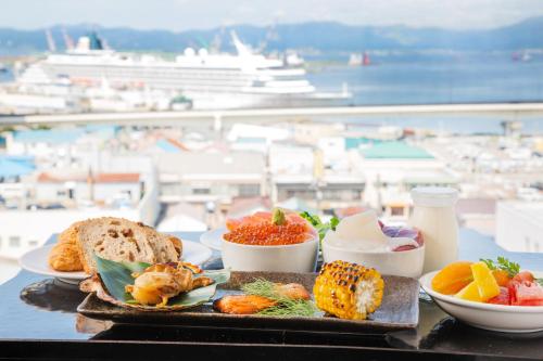 bandeja con comida en una mesa con vistas al puerto en Hotel Resol Hakodate, en Hakodate