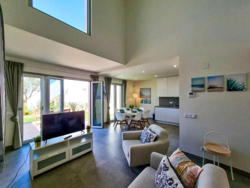 a living room with a flat screen tv and a couch at FLH Vilamoura Duplex with Terrace & Pool in Vilamoura