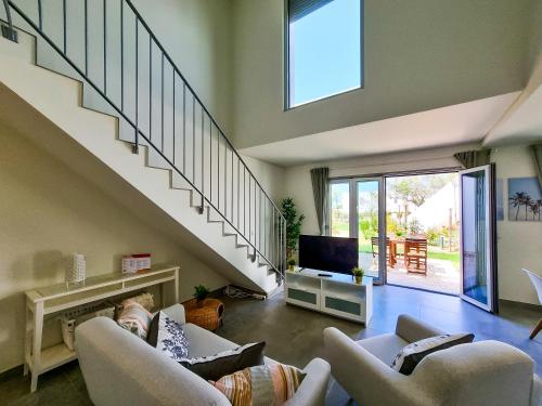 a living room with two couches and a staircase at FLH Vilamoura Duplex with Terrace & Pool in Vilamoura