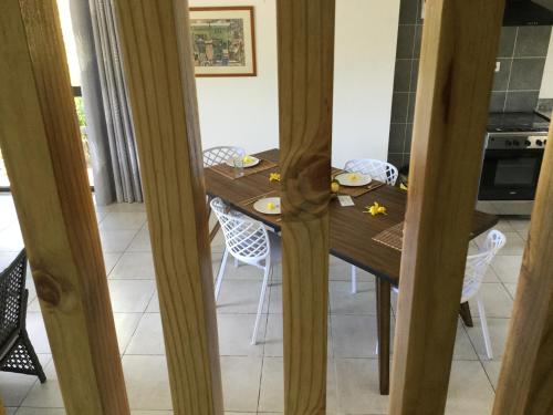 a dining room with a wooden table and chairs at Bougainvillas Seychelles in Anse Royale