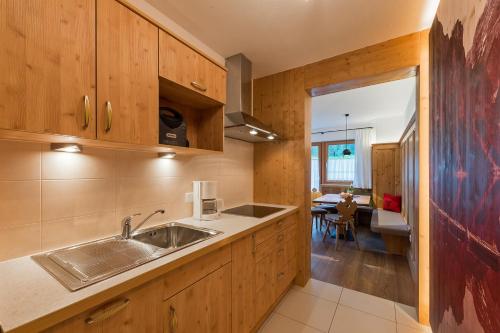 a kitchen with wooden cabinets and a sink at Roderhof in Braies