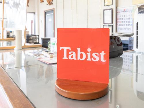 a red tablet sign sitting on a counter in a store at Tabist Izumi Yusen Shukuhaku Center in Izumi