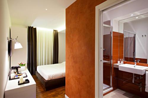 a hotel room with a bathroom with a sink and a bed at LaHouse Rome by Premium Suites Collection in Rome