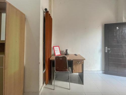 a desk in a room with a table and a chair at RedDoorz Syariah near Siloam Hospital Mataram in Mataram