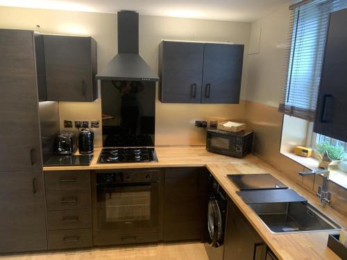 a kitchen with wooden counters and a stove top oven at Column Mews Townhouse in Alnwick