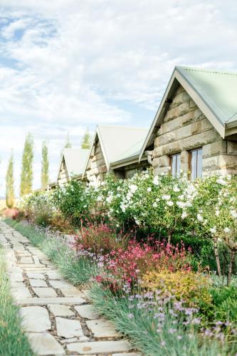 a stone path in front of a house with flowers at Baris Guesthouse in Clarens