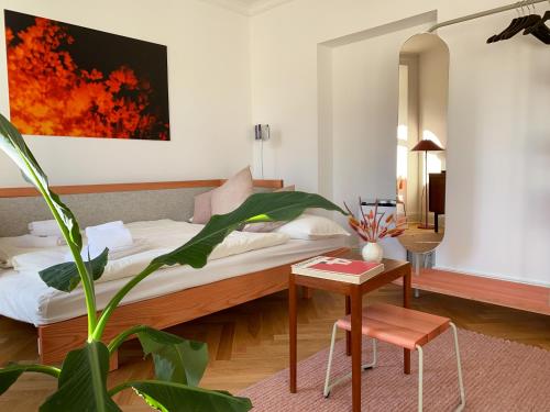 een slaapkamer met een bed en een tafel en een plant bij WELL Pretty Places - sustainable interior design in the Citycenter in Kassel