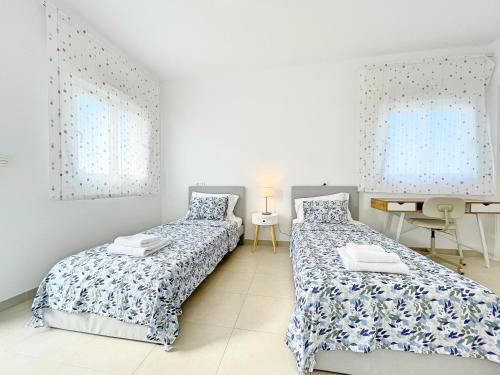 Perfect Getaway Villa في غران ألاكانت: غرفة نوم بسريرين ومكتب وطاولة