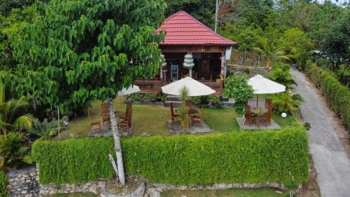 an aerial view of a house with chairs and umbrellas at Sakti OceanView Nusa Penida in Nusa Penida