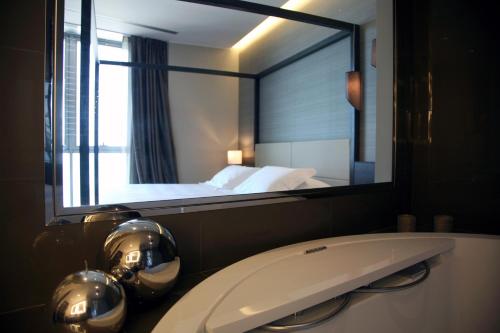 a bathroom with a mirror and a sink and a bed at Ego Hotel in Ancona