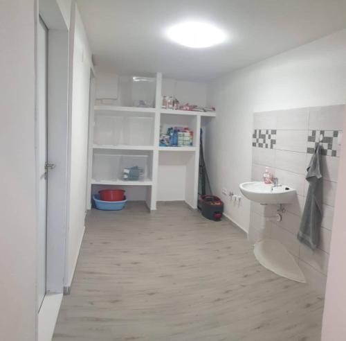 La salle de bains blanche est pourvue d'un lavabo et de toilettes. dans l'établissement Rodinný penzion Mayer, à Pouzdřany