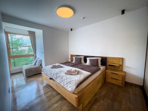 una camera con un grande letto e una finestra di Apartmán s výhľadom na štíty Ovruč 312 a Štrbské Pleso