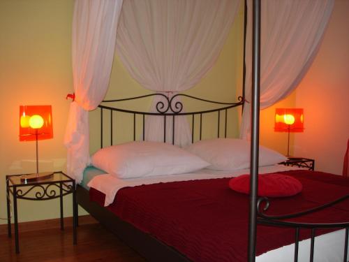 a bedroom with a canopy bed with two lamps at Apartments Dalmatina in Zaton