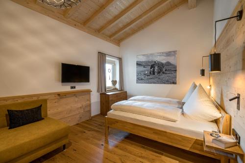 a bedroom with a bed and a tv on the wall at Die Zwei Sonnen Chalets in Ofterschwang