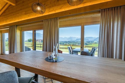 a dining room with a large wooden table and chairs at Die Zwei Sonnen Chalets in Ofterschwang