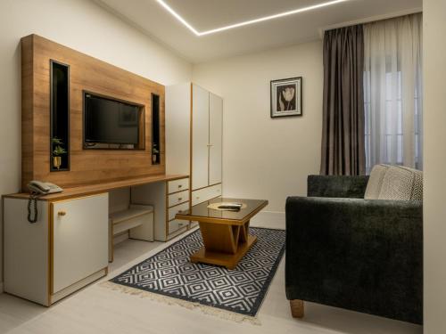 a living room with a couch and a tv and a chair at Prestige Hotel Suites - برستيج للشقق الفندقية in Amman