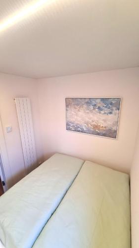 a bedroom with a bed and a painting on the wall at Hausboot La Mare Emma in Weyhe