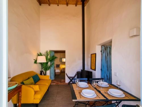 a living room with a yellow couch and a table at FLH Vale Judeu Rustic Mezzanine Cottage I in Loulé