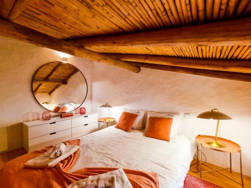 a bedroom with a large bed and a mirror at FLH Vale Judeu Rustic Mezzanine Cottage I in Loulé