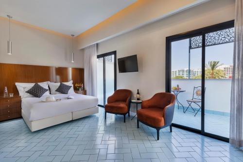 エイラットにあるPlay Eilat Hotelのベッド1台と椅子2脚が備わるホテルルームです。