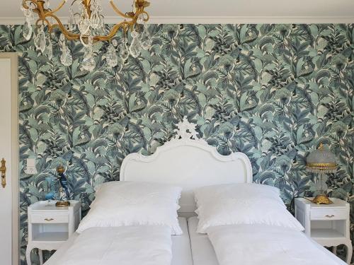 a bedroom with two beds and a floral wallpaper at Gästehaus - Im Gärtle II in Niederrotweil