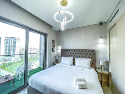 een slaapkamer met een groot bed en een groot raam bij STAY BY LATINEM Luxury 2BR Holiday Home CV B1309 Near Burj Khalifa in Dubai