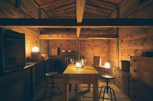 a kitchen with a wooden table and stools in it at Kominkayado LOOF Kyonoie in Ōwatari
