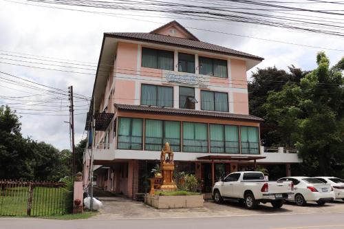 budynek z samochodami zaparkowanymi przed nim w obiekcie OYO 75408 Tipsiri Place w mieście Chiang Mai