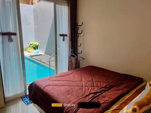- une chambre avec un lit et une fenêtre avec une piscine dans l'établissement Villa Maryam Batu, à Tlekung