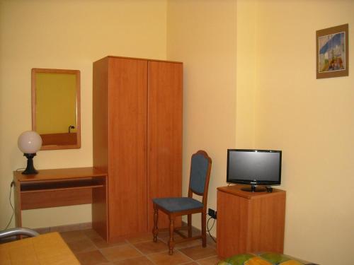 a room with a tv and a cabinet and a chair at Cascina Ricca in Roddino