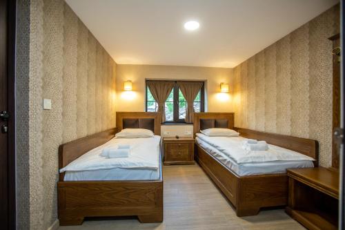 2 łóżka pojedyncze w pokoju z oknem w obiekcie Семеен Хотел Чардаците w mieście Lovech