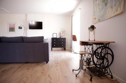 a living room with a couch and a table at Le petit Loré in Sainte-Suzanne