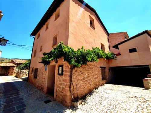 a brick building with a tree on the side of it at Hotel Albarrán in Albarracín