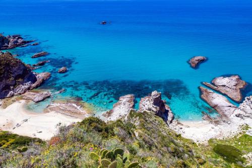 an aerial view of a beach with rocks and water at Solmaris Tropea Rooms & Suites in Tropea