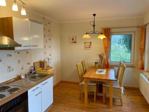 a kitchen with a wooden table and a dining room at Hotel Gutshaus Kajahn in Gustow