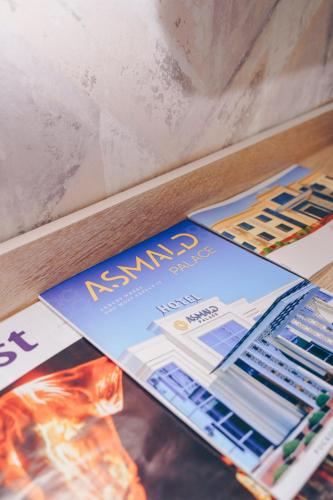 a pile of magazines sitting on top of a table at Asmald Palace Hotel in Kokand