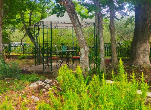 a table and chairs in a garden with trees at Isolated Villa Terna -Big Garden-Pool-Dalmatia in Slime