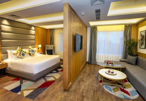 Habitación de hotel con cama y sofá en Ramada by Wyndham Katra Station Road, en Katra