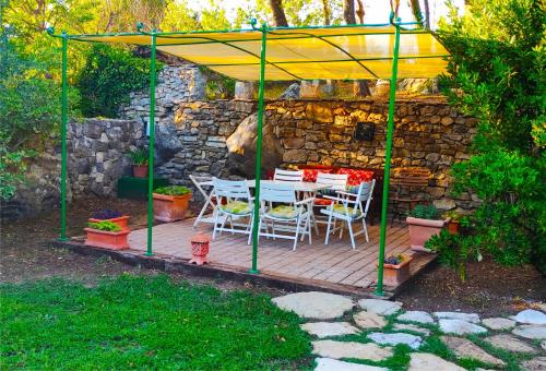 a patio with a table and chairs under a yellow umbrella at Isolated Villa Terna -Big Garden-Pool-Dalmatia in Slime