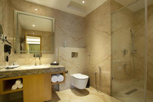 La salle de bains est pourvue d'une douche, d'un lavabo et de toilettes. dans l'établissement Ramada by Wyndham Katra Station Road, à Katra