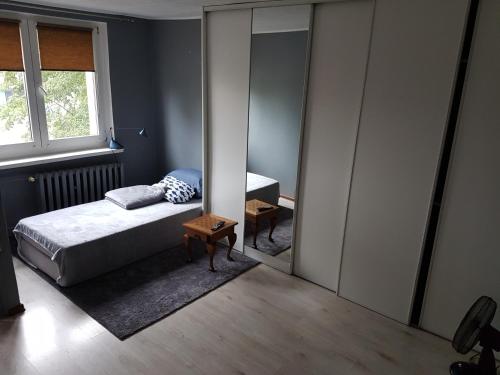 1 dormitorio con espejo, cama y mesa en Mieszkanie jednopokojowe Bolesławiec w centrum - wymagana kaucja zwrotna, en Bolesławiec